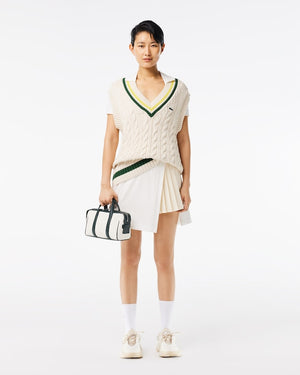 Person wearing a white and green outfit with a bag on a white background