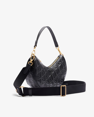 Black quilted handbag with gold accents on a light gray background
