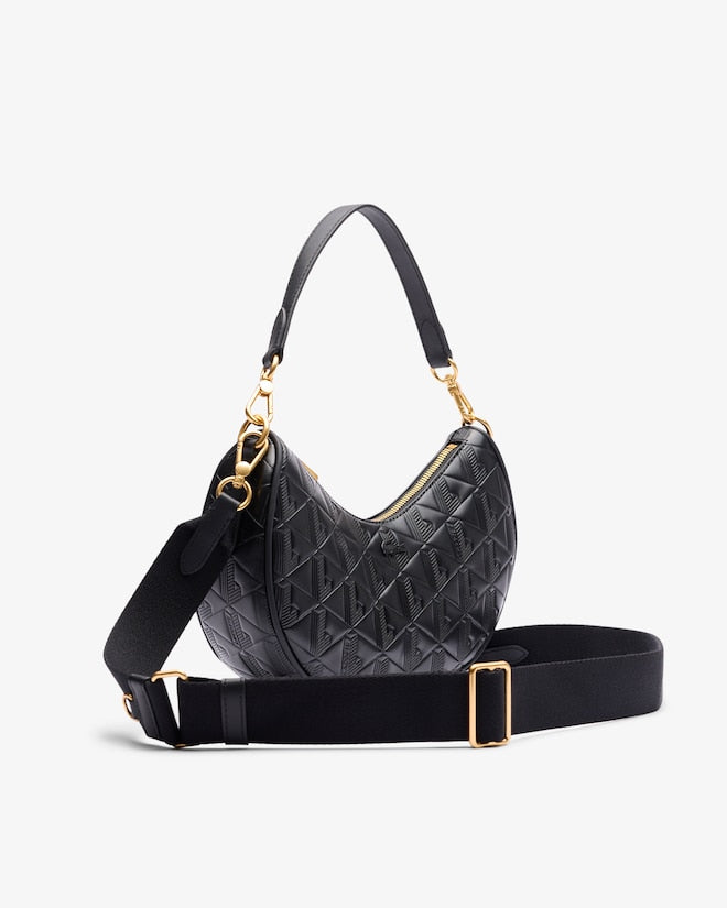 Black quilted handbag with gold accents on a light gray background