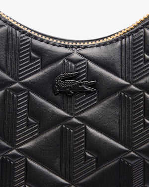 Close-up of a black textured handbag with a brand logo on a white background