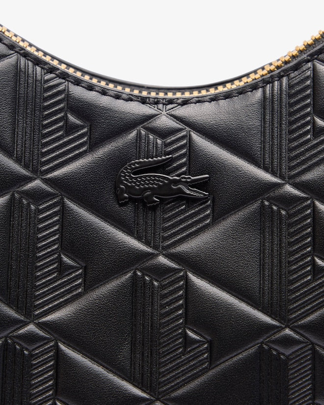 Close-up of a black textured handbag with a brand logo on a white background