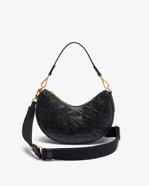 Black quilted handbag with gold accents on a light gray background