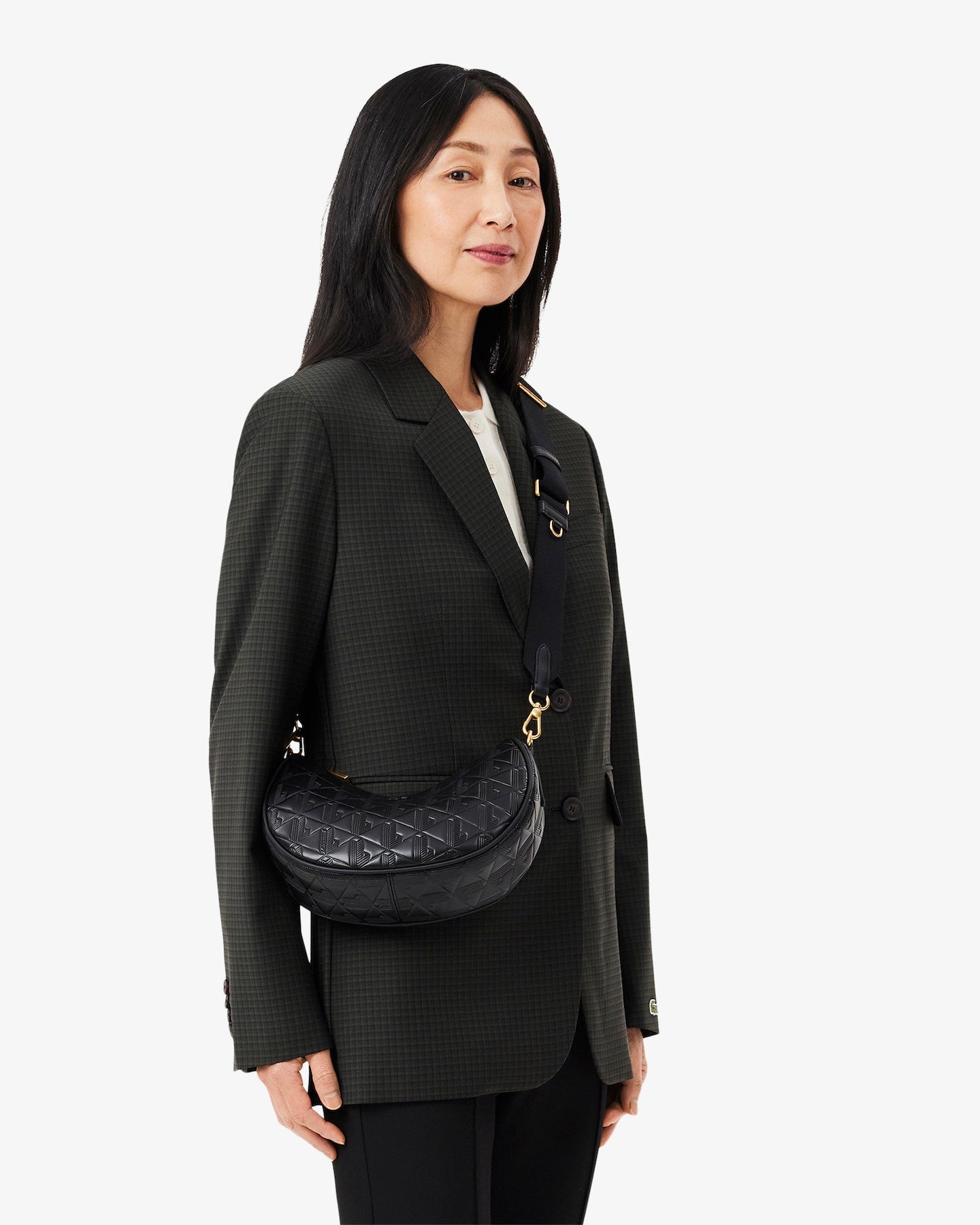 Woman wearing a black blazer with a black bag on a white background